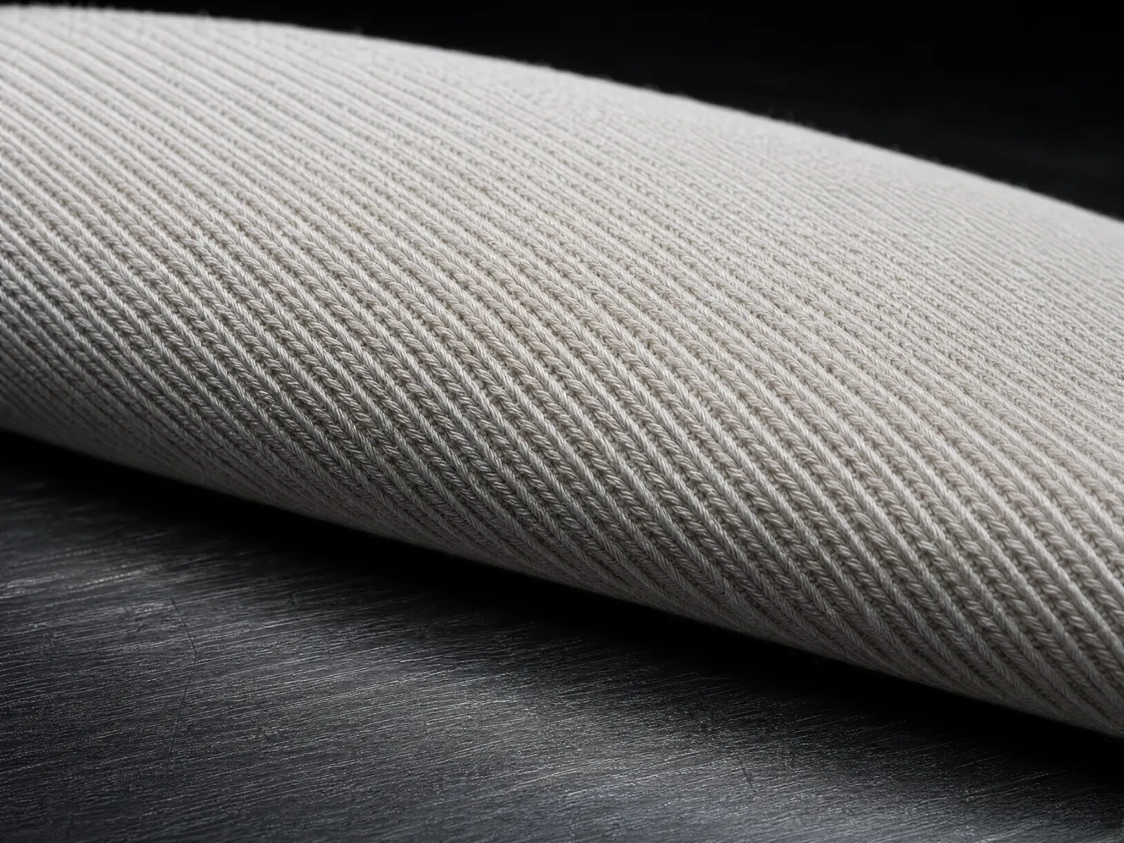 Macro of fine seamless knitted jersey in bone, stretched over a curve