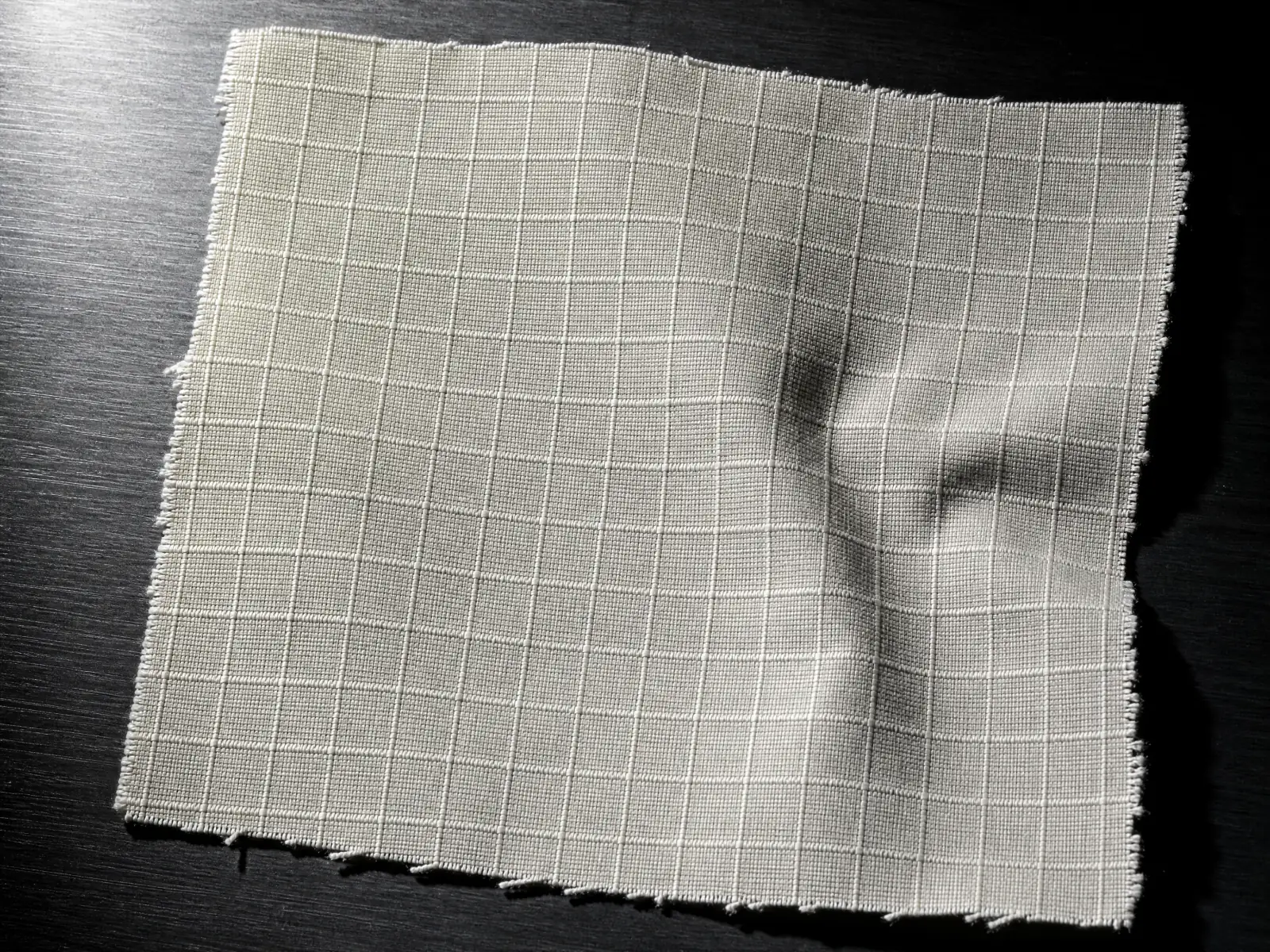 Macro of undyed bone ripstop, the reinforcement grid raised across the weave